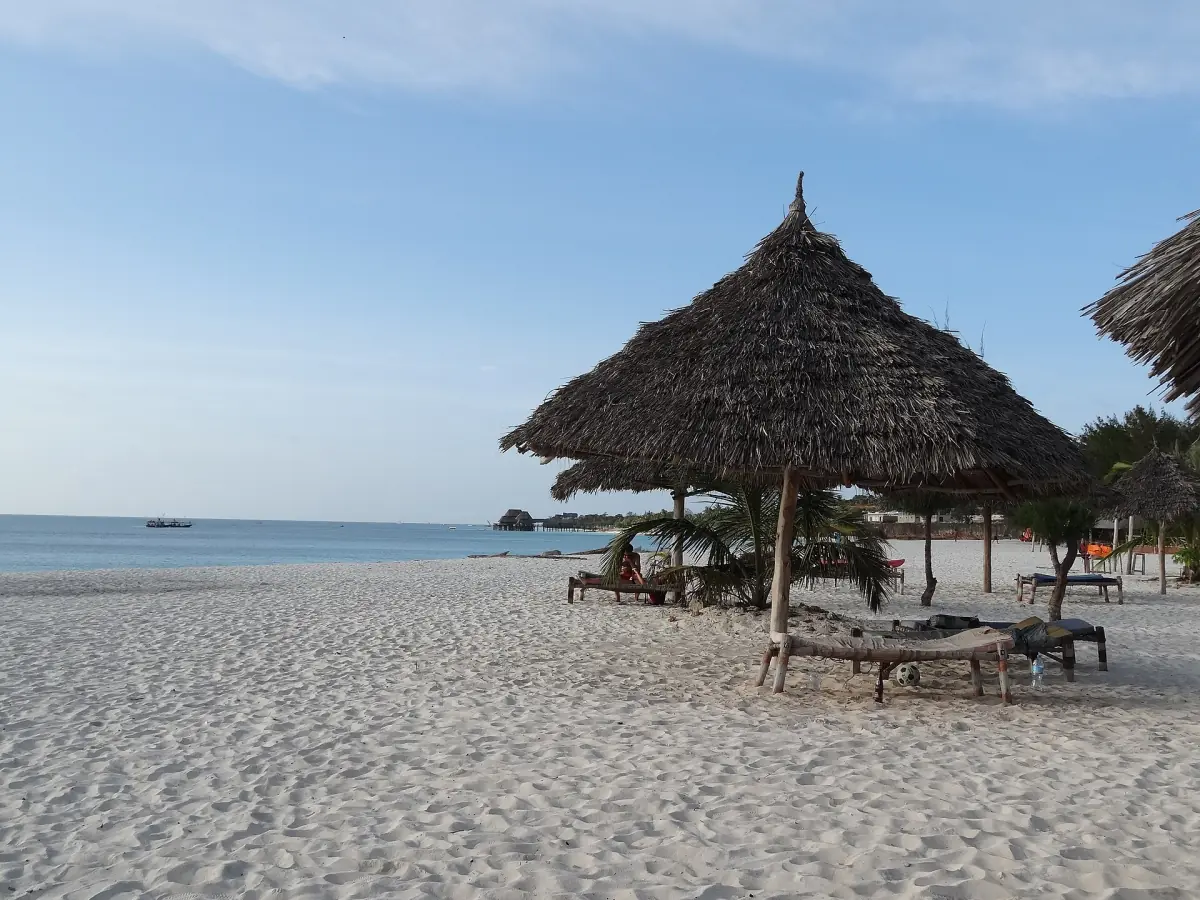 Thatched beach shade on empty sand at Kendwa under a blue sky