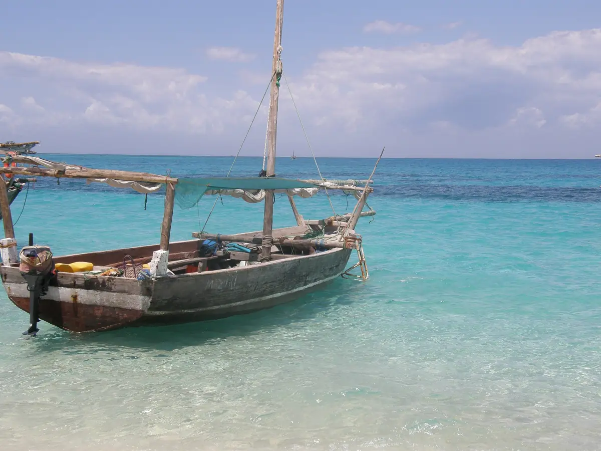 Wooden dhow-style boat moored in clear turquoise water near Kwale Island