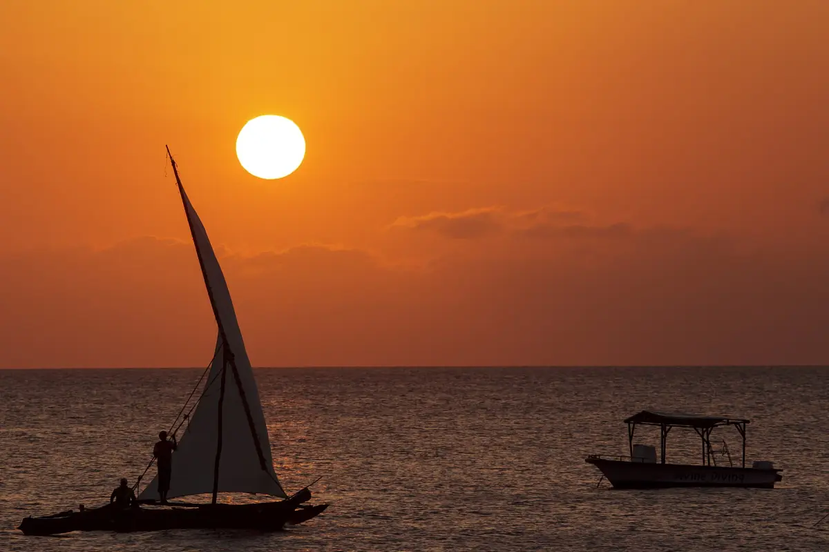 Dhow silhouetted against an orange sun low over the sea