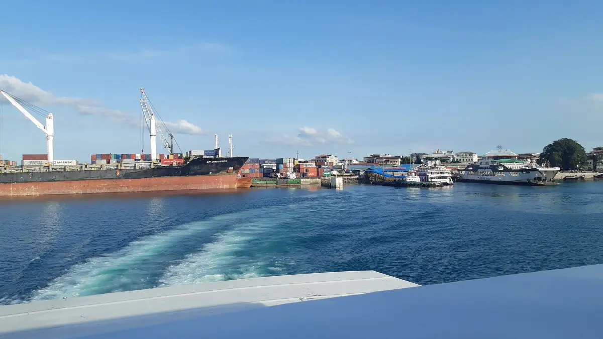 Ferry arriving among cargo ships in the harbour of Zanzibar
